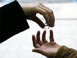 Hombre entregando dos anillos de matrimonio a una persona